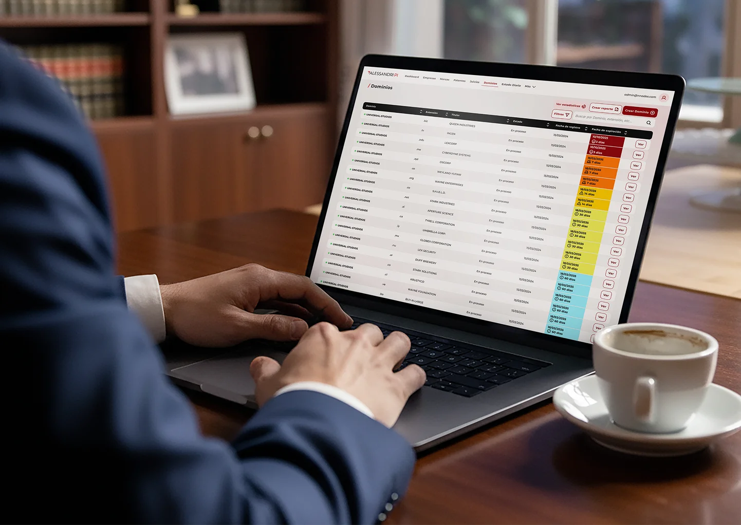 Persona usando una laptop con una tabla de dominios web y fechas de expiración que están codificadas por color.
