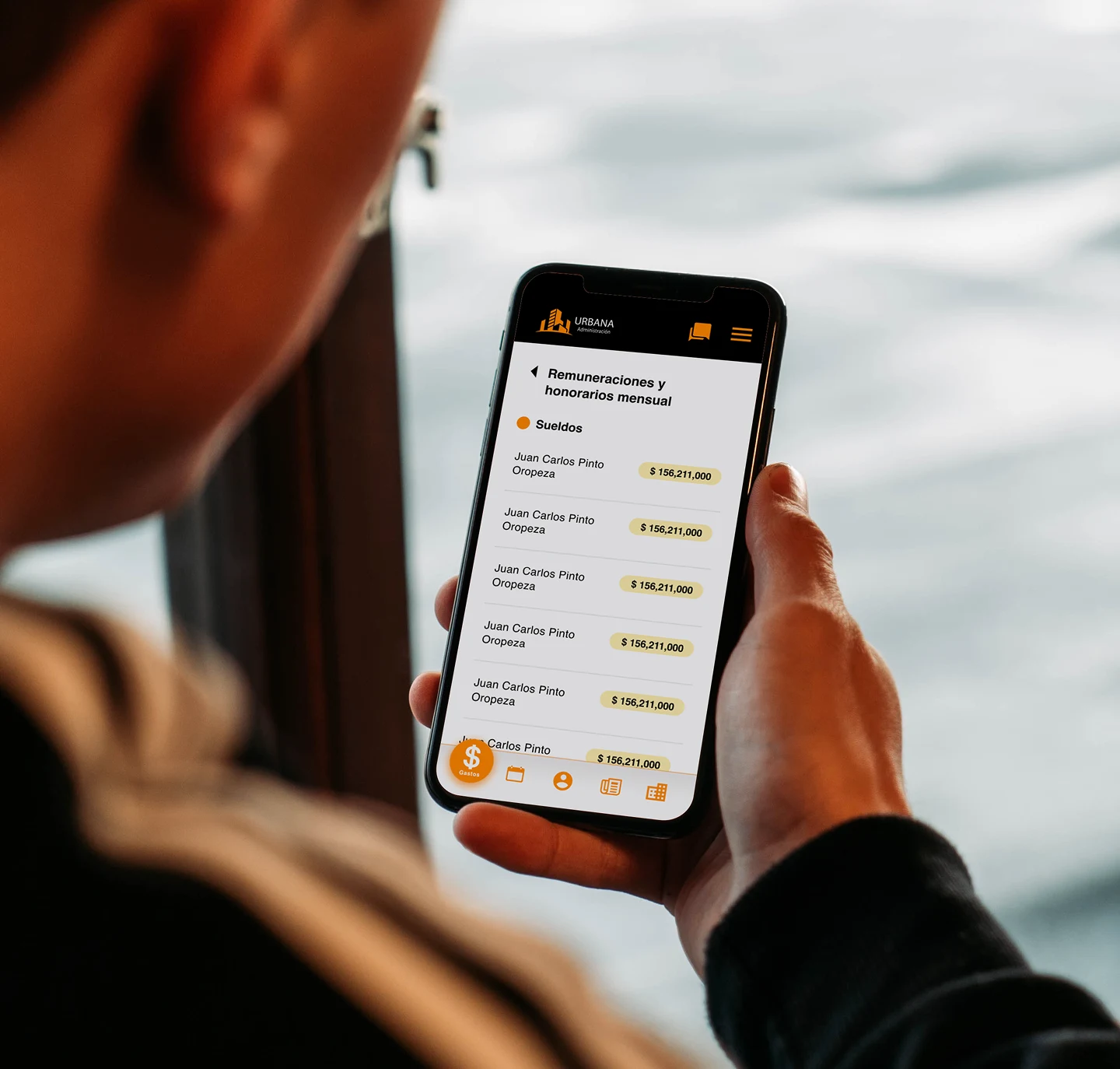 Persona revisando la sección de remuneraciones y honorarios mensuales en la app Urbana Administración.
